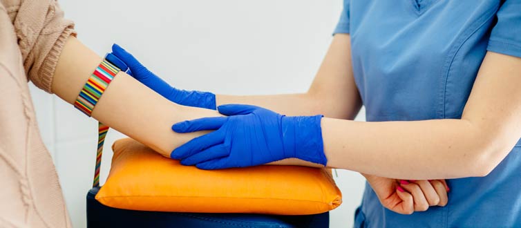 Nurse taking blood pressure of patient using a rainbow cuff.