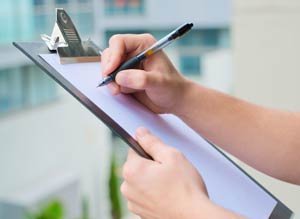 Hand checking off items on a clipboard