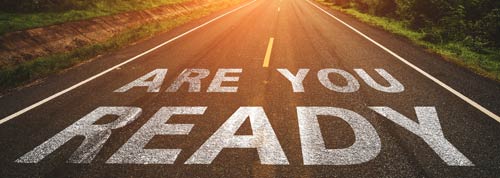 Two-lane road with the words ARE YOU READY across both lanes