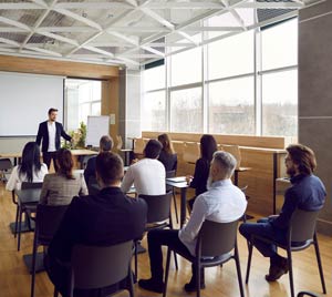 Informal class setting for businesspeople with male instructor in front of room