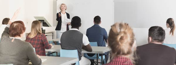 Female instructor at front of classroom of adult business students