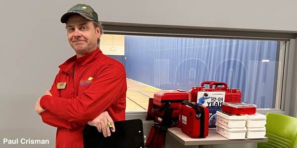 Paul Crisman holding clipboard in his office.